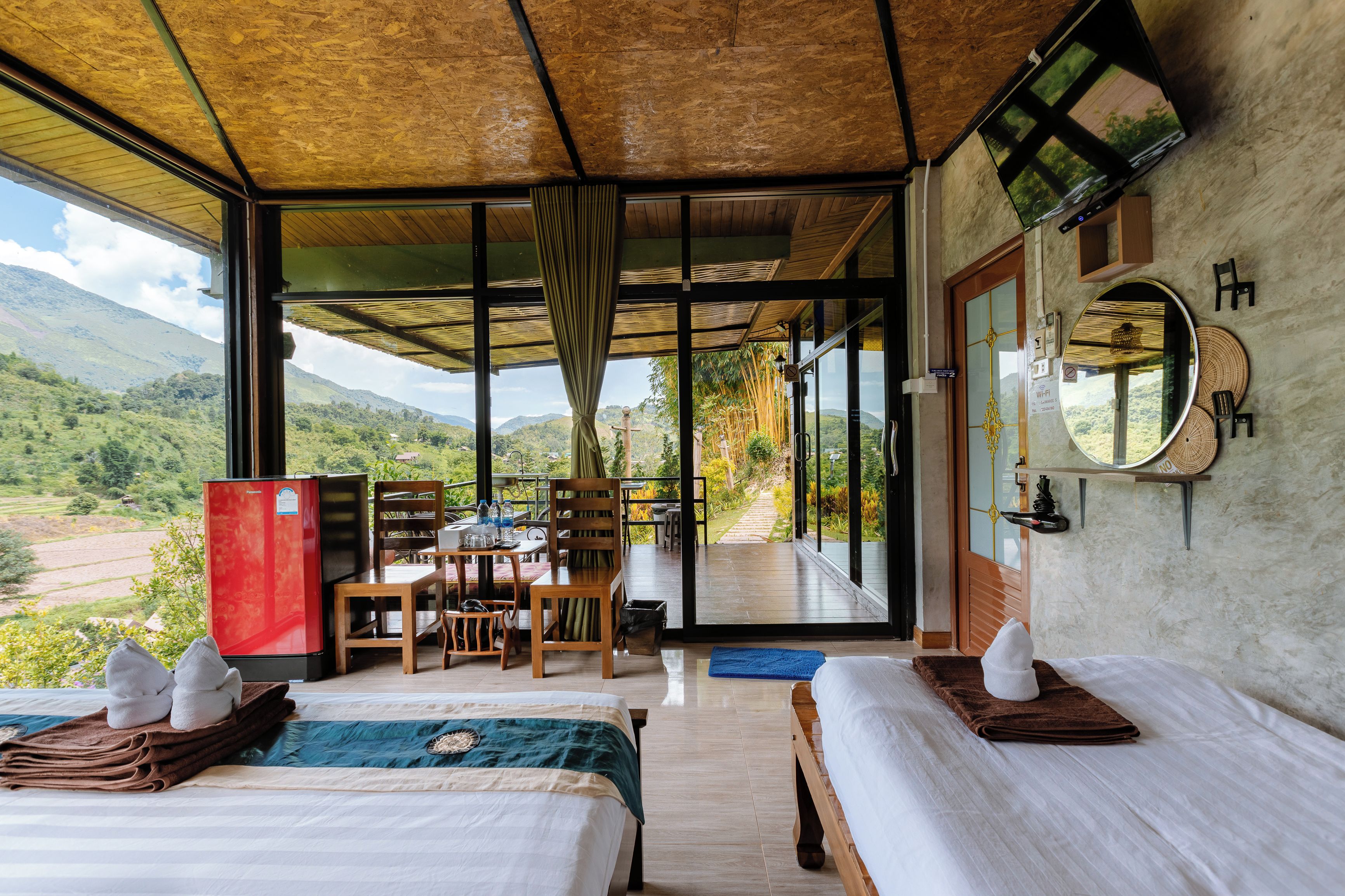 A hotel room with a bed, a desk, and a view of the mountains.
