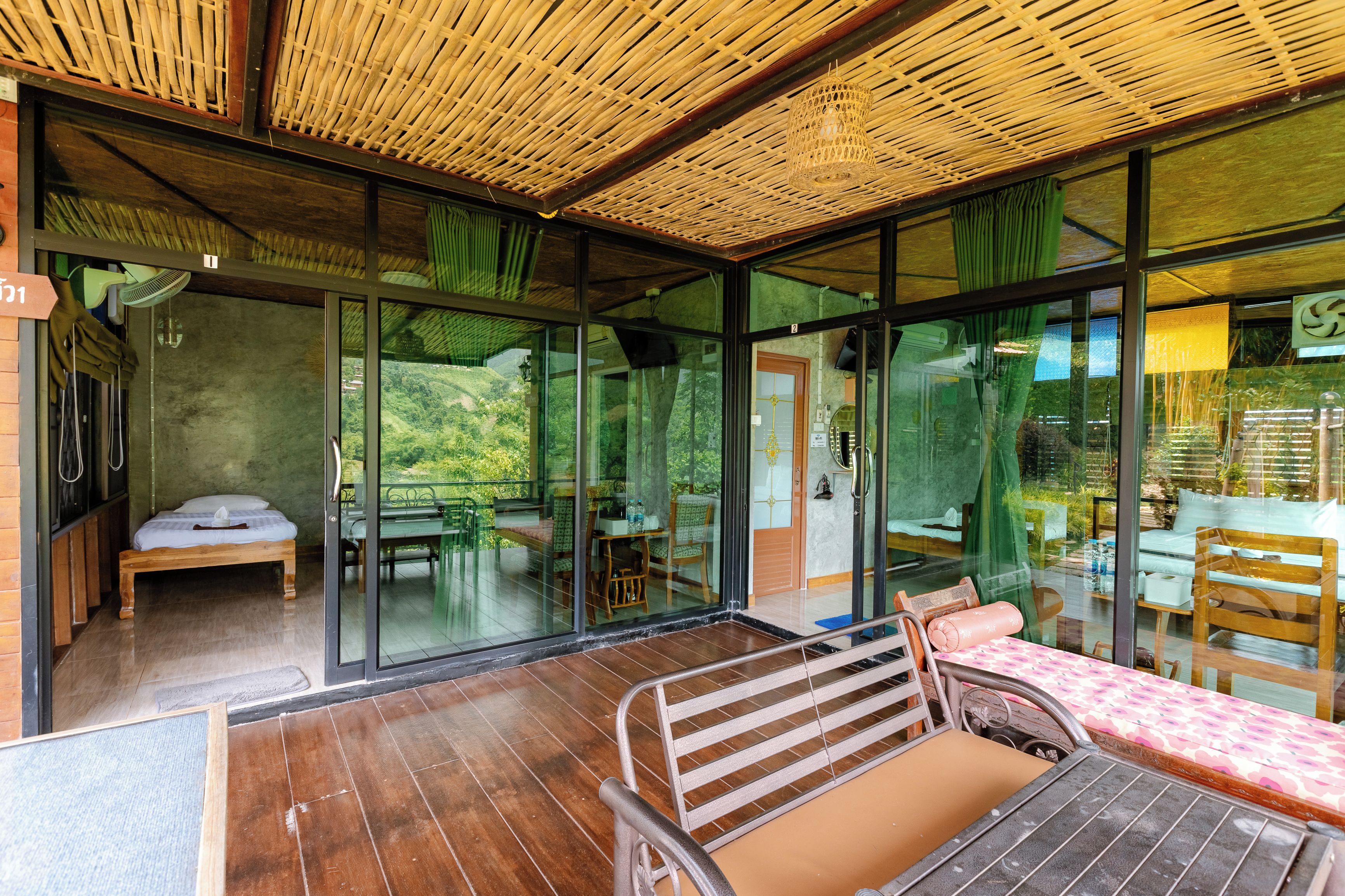 Una habitación con cama, mesa y silla, y vista a espacios verdes.