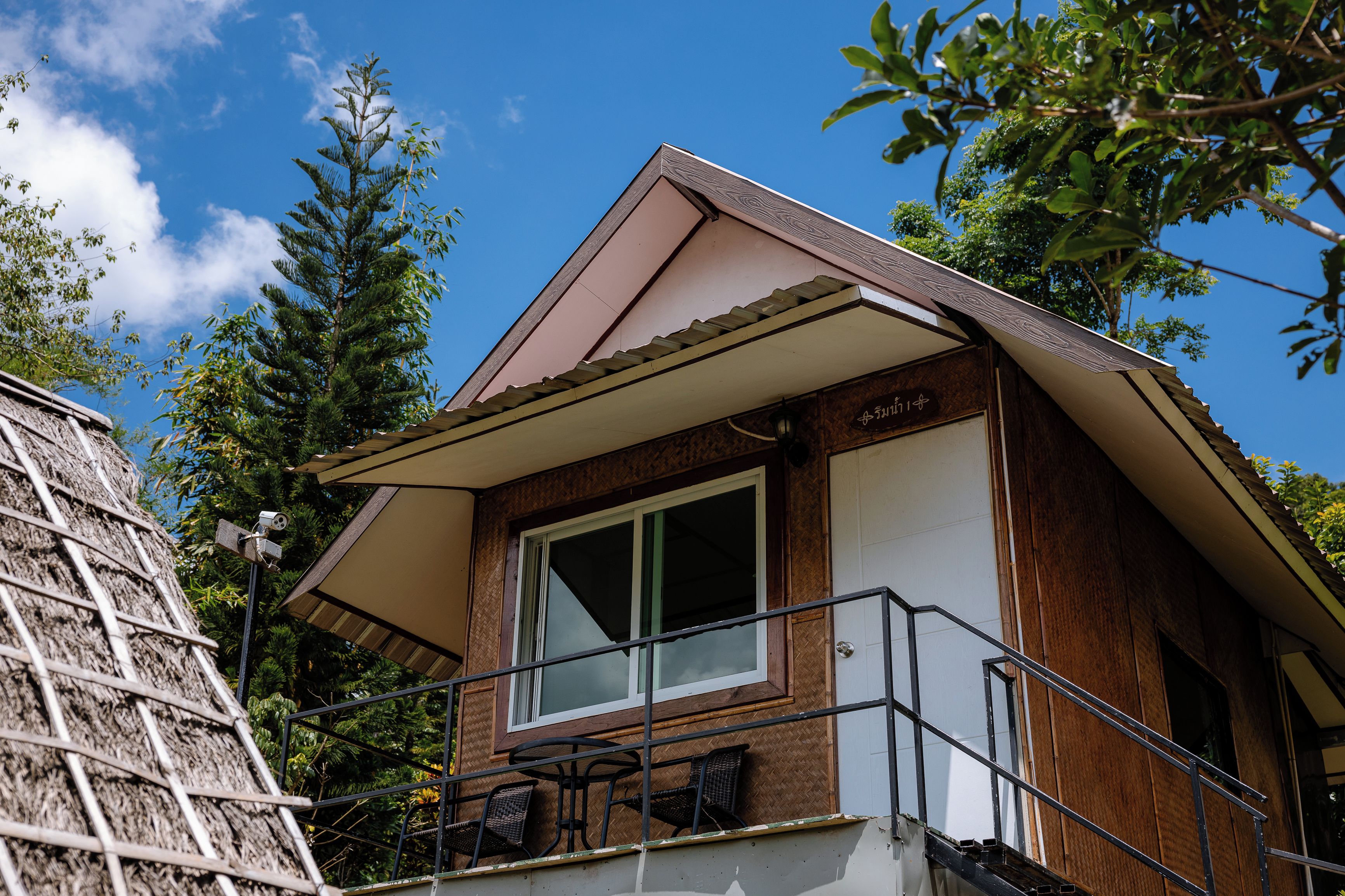 A two-story building with a balcony, a window, and a door.
