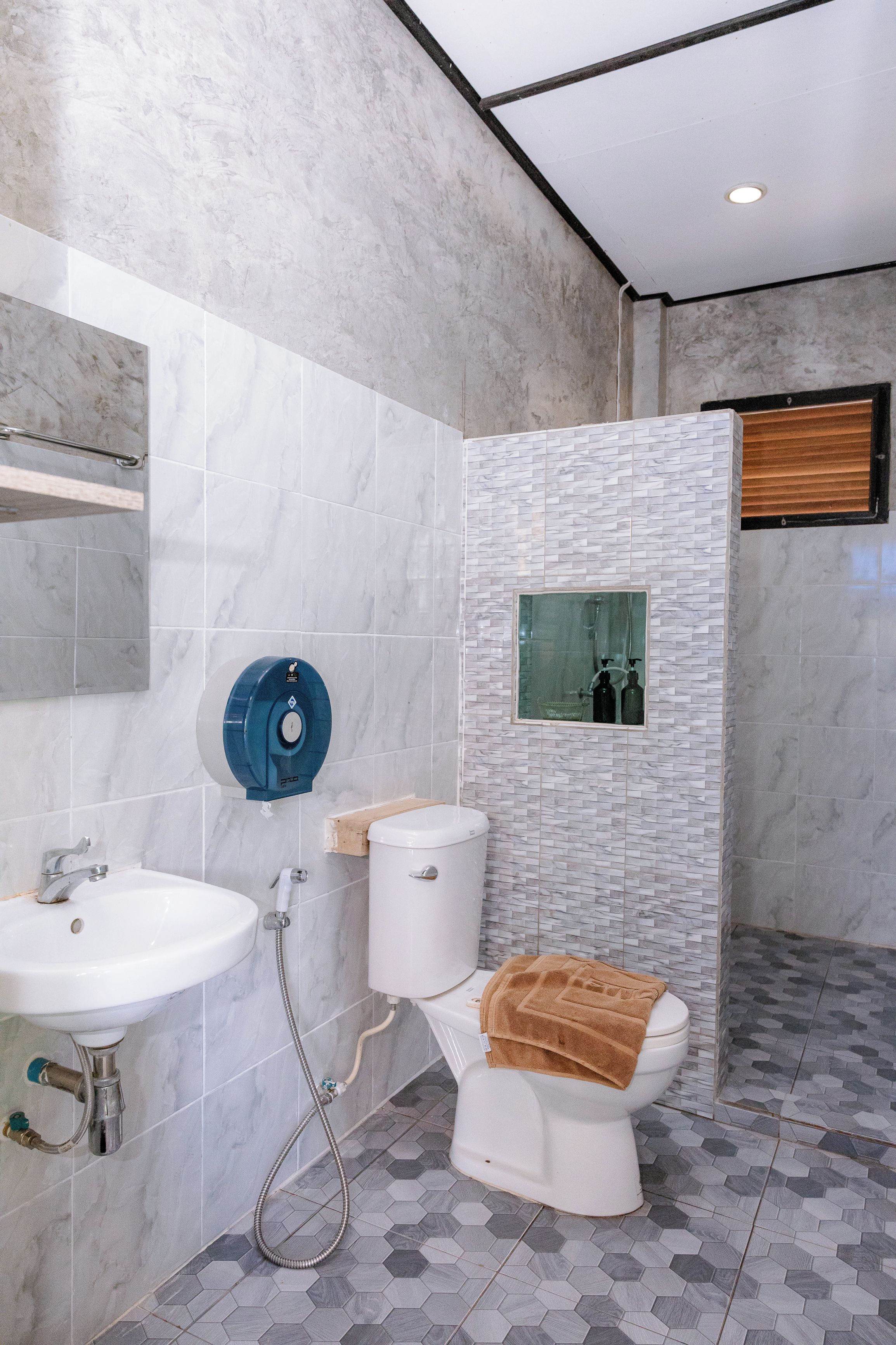 A modern bathroom with a white sink, toilet, and shower.