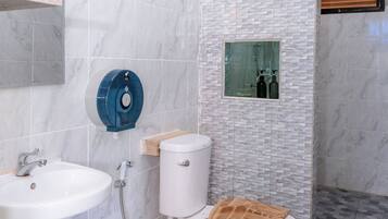 A modern bathroom with a white sink, toilet, and shower.