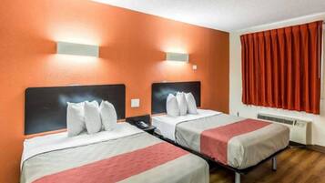 A hotel room with two beds, a red curtain, and a wall-mounted heater.