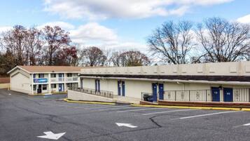 A motel with a lobby, multiple rooms, and a parking lot.