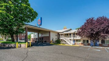 Un motel con un letrero de McDonald's, una zona de estacionamiento techada y un edificio con una escalera.