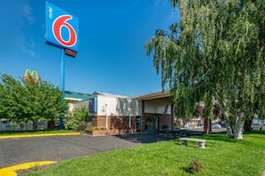 A motel with a large blue sign, a McDonald's logo, and a parking lot. - 1 Queen Bed | Non-Smoking (Clarkston)