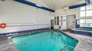 Una piscina interior con agua cristalina, un flotador salvavidas y un borde de azulejos azules.