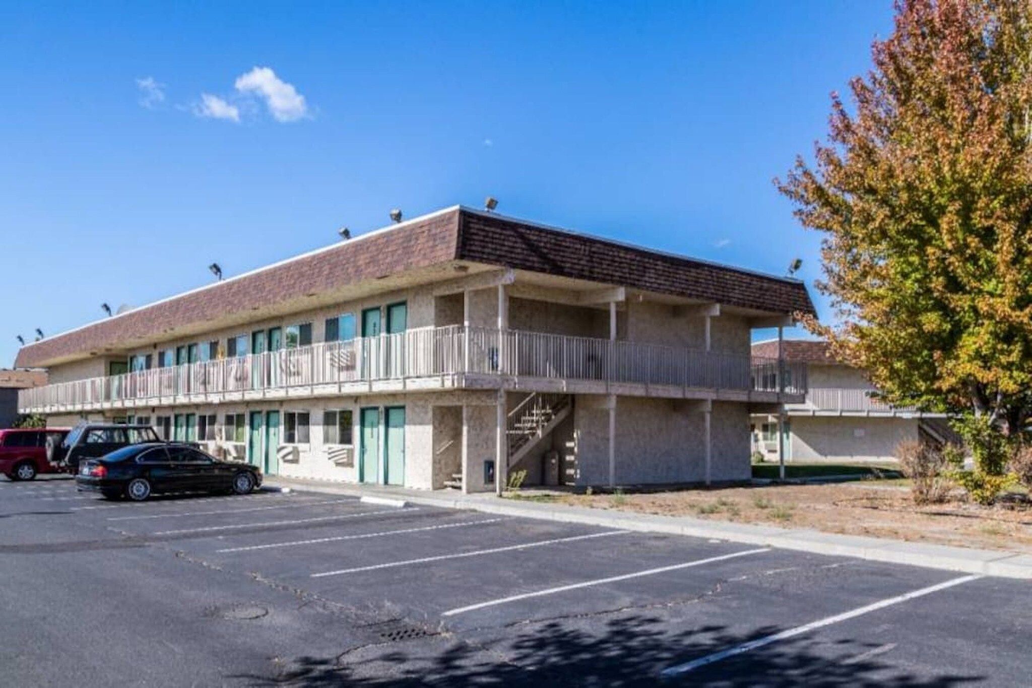 A two-story motel with a parking lot in front.