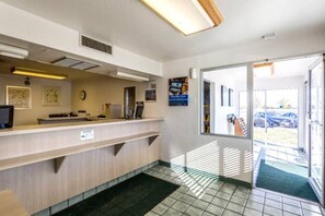 Un'area reception con un banco, una sveglia e una porta che dà sull'esterno.