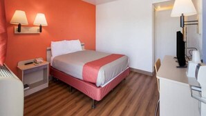 A hotel room with a bed, bedside tables, a desk, and a chair. - 1 Queen Bed | Mob Acc RI Shwr Nsmk Micfridg (Moses Lake)