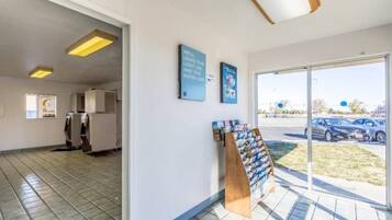 A clean, modern interior with a reception area, a display rack, and a view of the parking lot through the glass door.