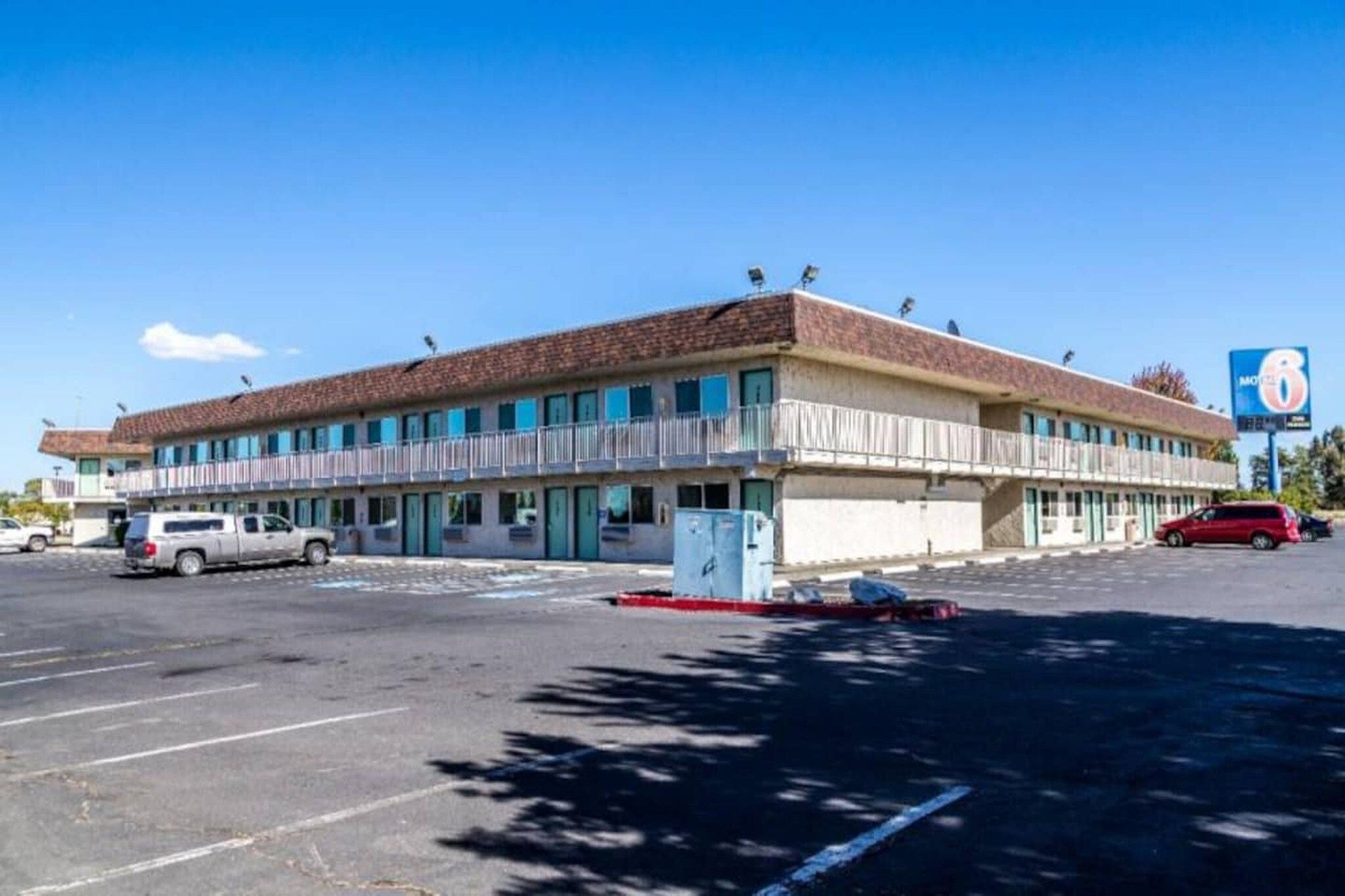 A two-story motel with a parking lot in front.