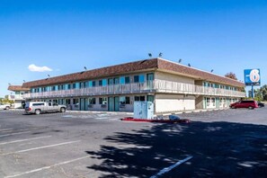 Ein zweistöckiges Motel mit Parkplatz davor.