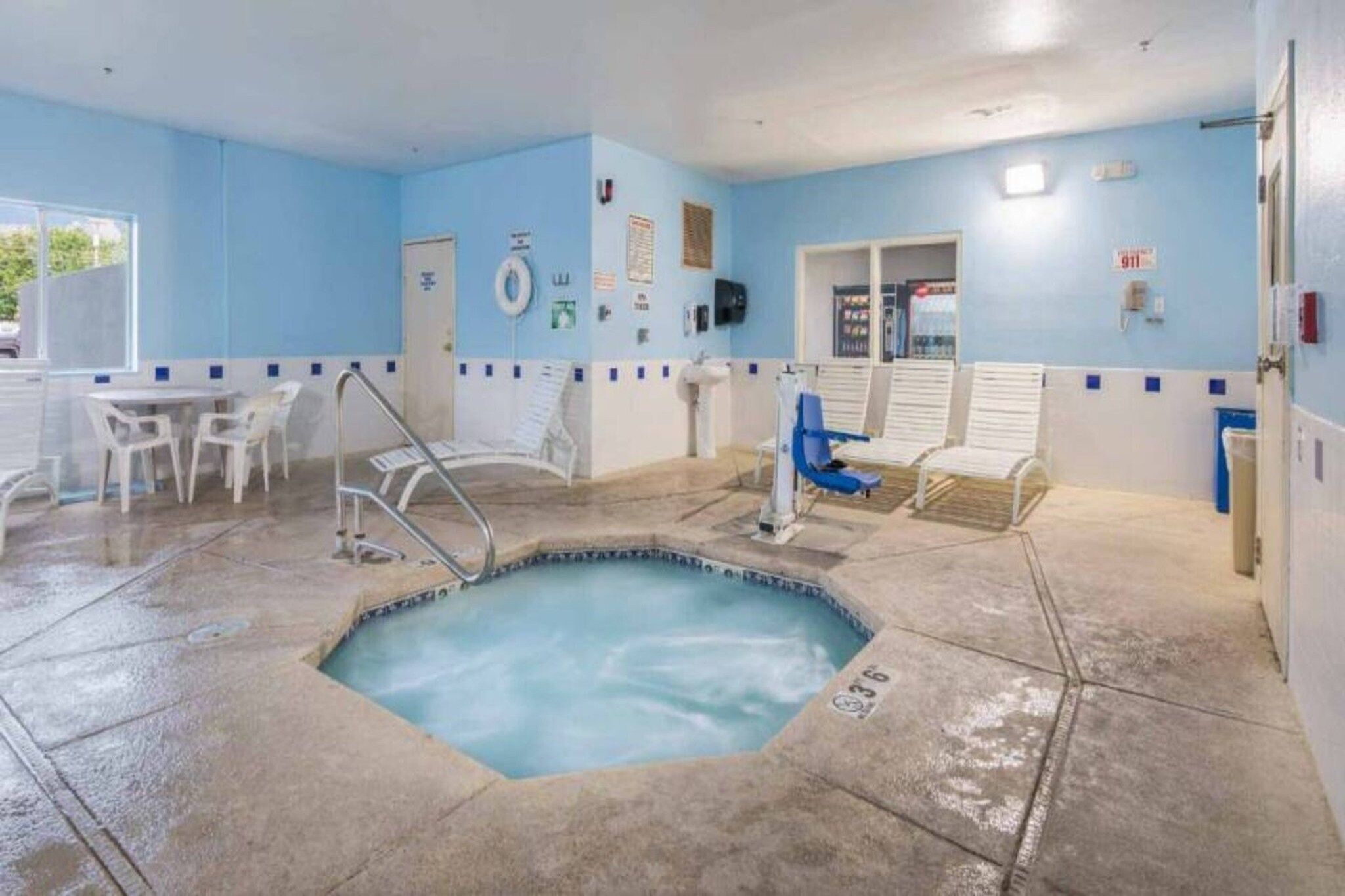 Ein Poolbereich mit Whirlpool, Liegestühlen und einer kleinen Sitzecke mit Tischen.
