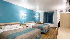 A hotel room with two beds, a desk, a chair, a television, and a window with curtains. - Cozy 2-Bed Queen|Free Parking|Wifi (Roswell)