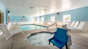 An indoor swimming pool with a hot tub, lounge chairs, and a clear ceiling. - Cozy 2-Bed Queen|Free Parking|Wifi (Roswell)