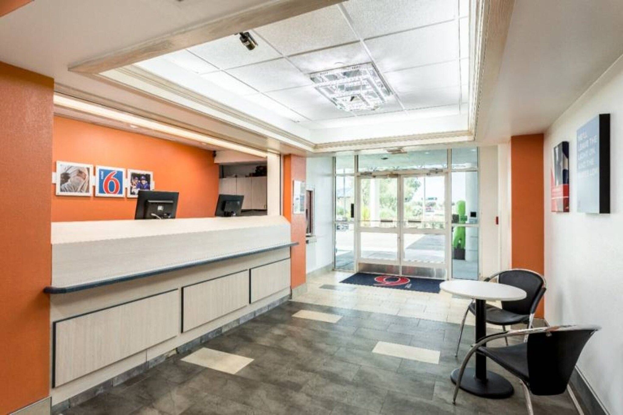 A reception area with a counter, chairs, and a glass door leading outside.