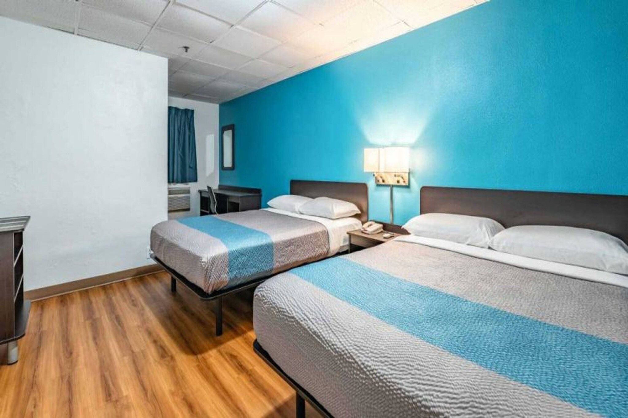 Ein Hotelzimmer mit zwei Betten, einem Schreibtisch und einem Sessel.