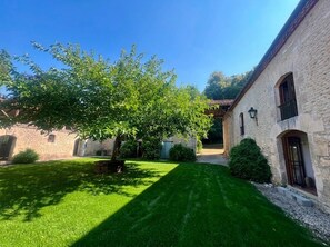 A stone building with a well-maintained lawn and a tree in the foreground. - Large property with privacy and private pool (La Chapelle-Grésignac)