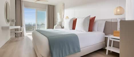Una habitación de hotel moderna con una cama grande, un escritorio, una silla y vistas a la ciudad.