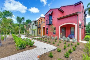 Zona residencial amb cases de colors, un camí pavimentat i jardins ben cuidats.