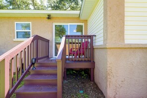 A wooden staircase leading to a door with a view of a backyard. - Walk to Dining: Relax at 609 Gray (Wildwood)