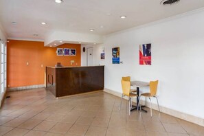 A reception area with a counter, two chairs, and a tiled floor.