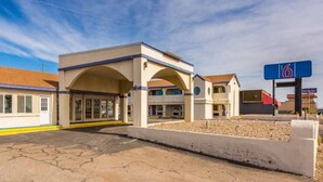 A motel with a central building, a parking lot, and a sign indicating the number 6. - 2 Queen Beds | Non-Smoking (Clovis NM)