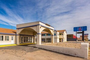 A motel with a central building, a parking lot, and a sign indicating the number 6. - 2 Queen Beds | Non-Smoking (Clovis NM)