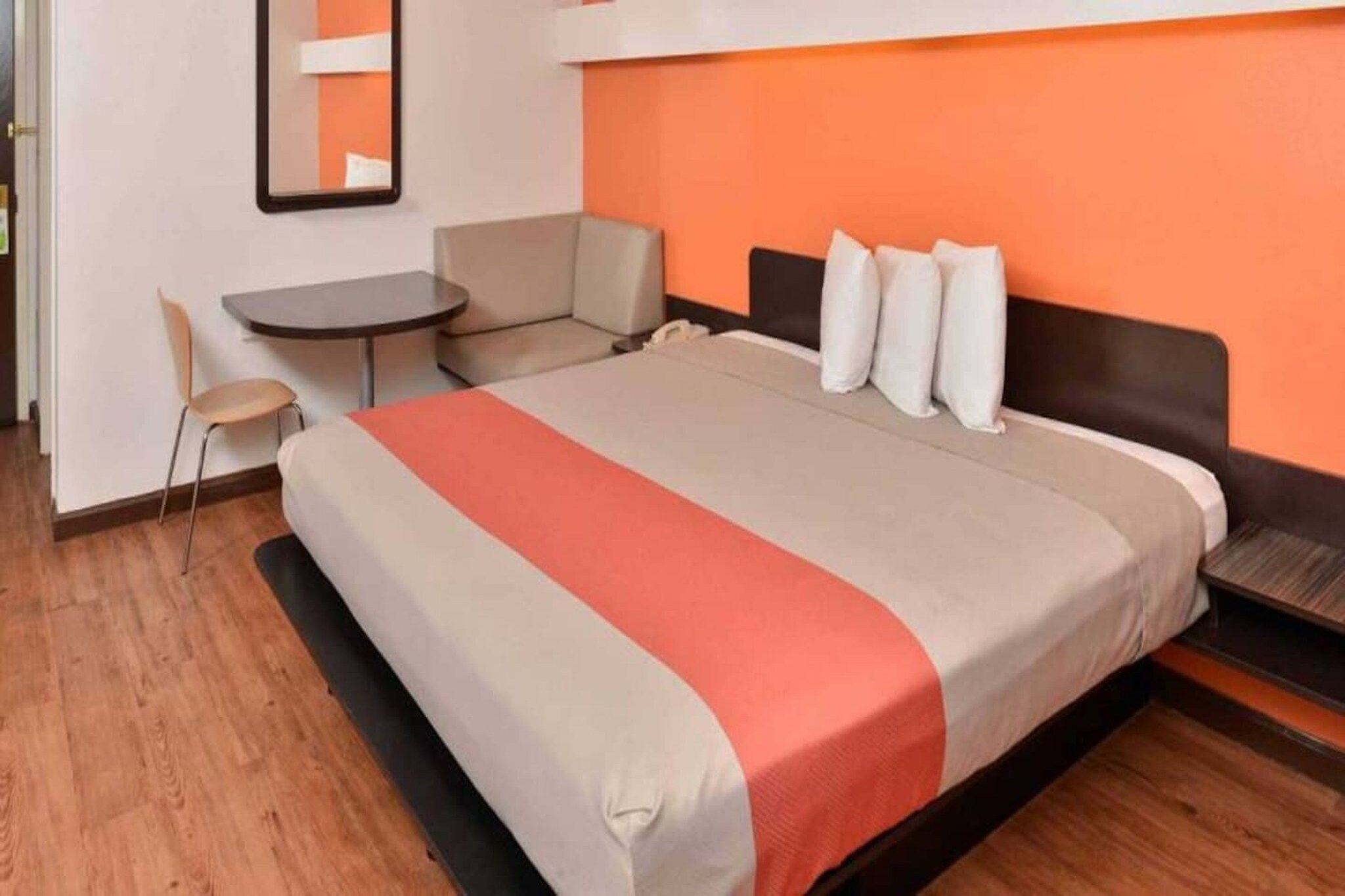 Une chambre d’hôtel avec un lit, un bureau et une chaise.