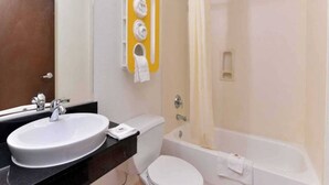 A bathroom with a sink, toilet, bathtub, and a shower area. - 1 King Bed | Smoking (RICHBURG)