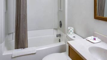 A bathroom with a bathtub, toilet, and sink.