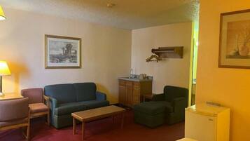 A compact living space with a sofa, a small table, a cabinet, and a refrigerator.