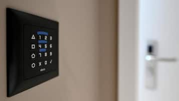 A wall-mounted electronic keypad, likely for room access, with a door visible in the background.