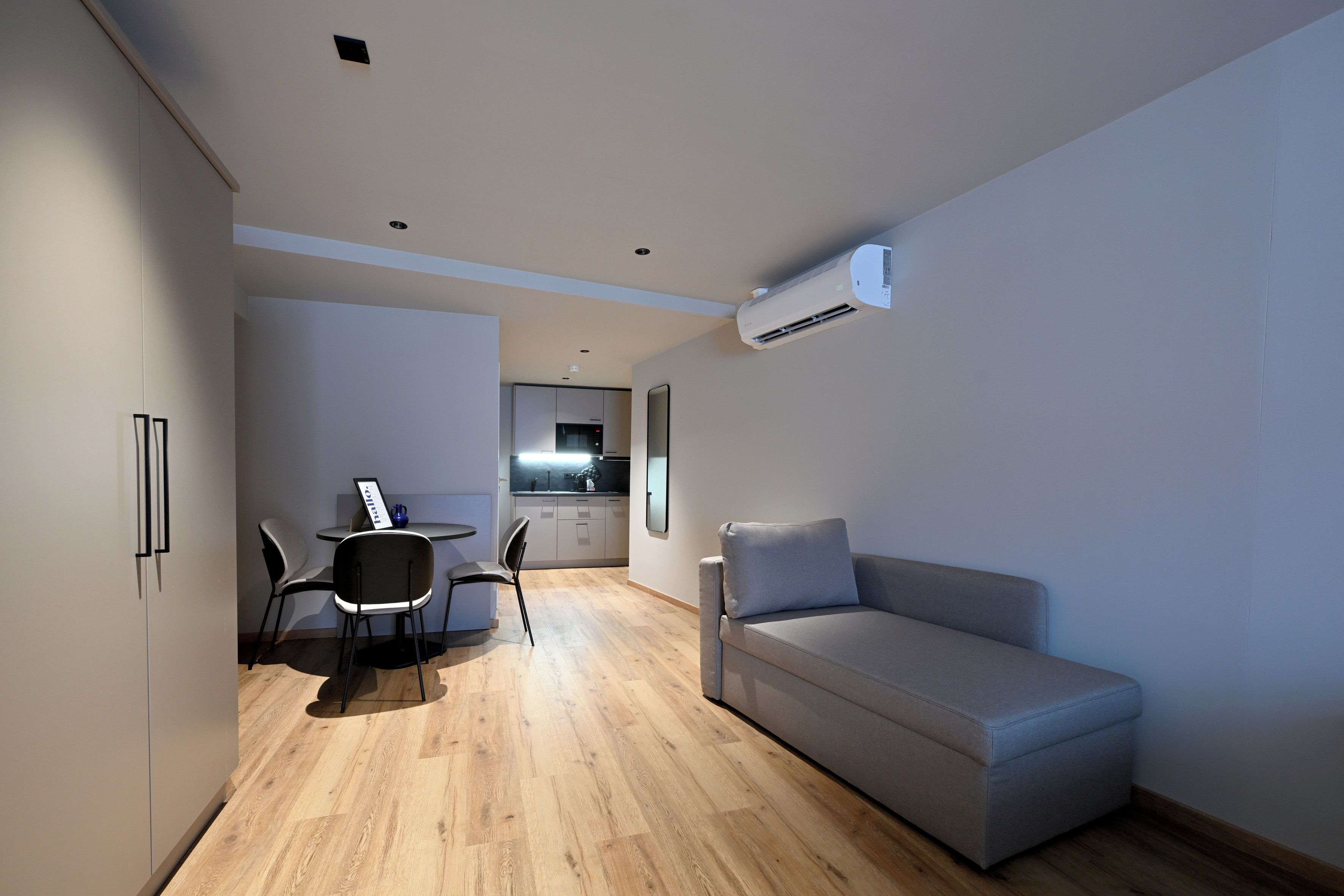 A compact living space with a kitchenette, a dining area, and a seating area.