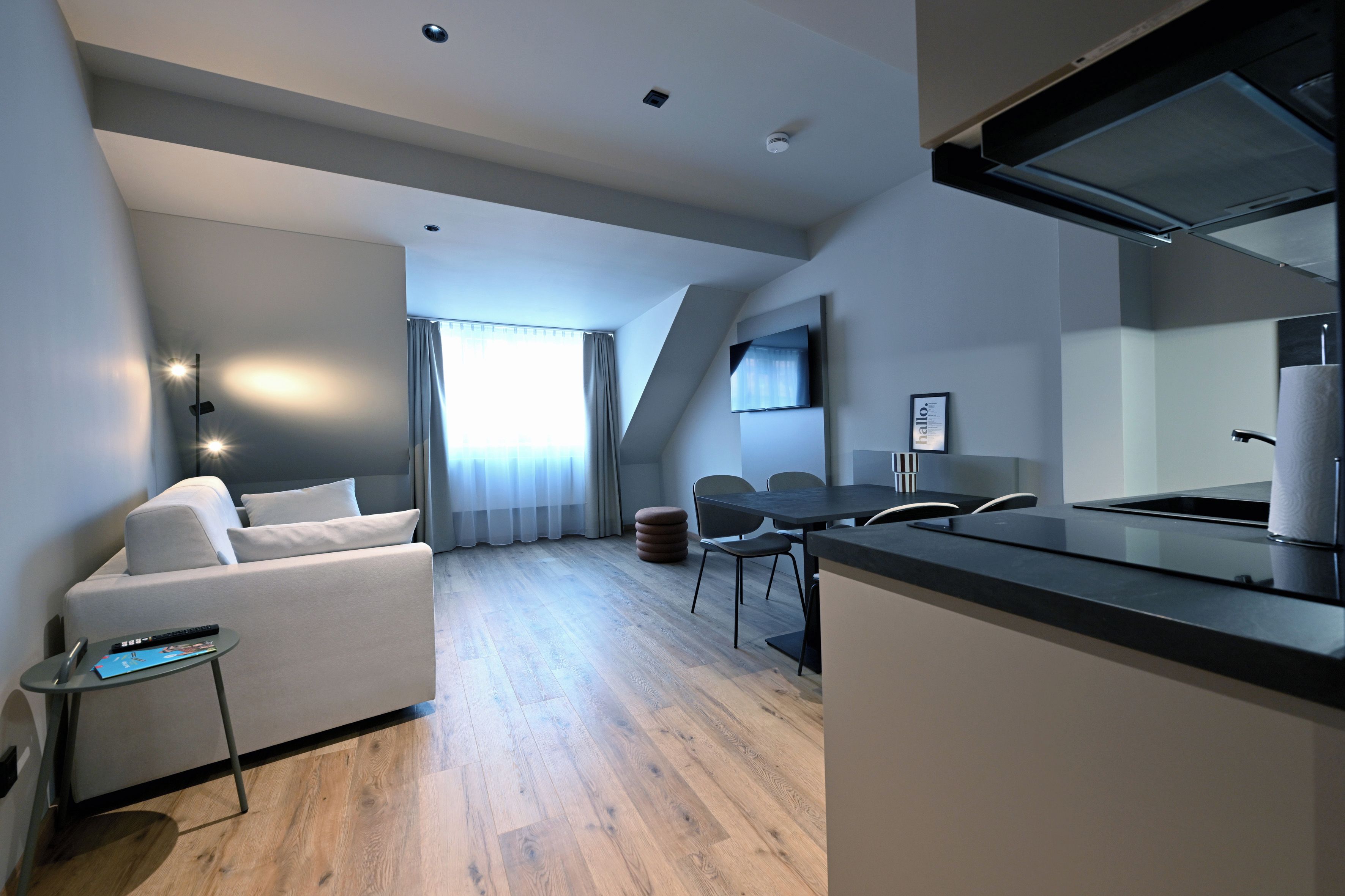 Un appartement moderne comprenant un espace de vie, un coin repas et une kitchenette.