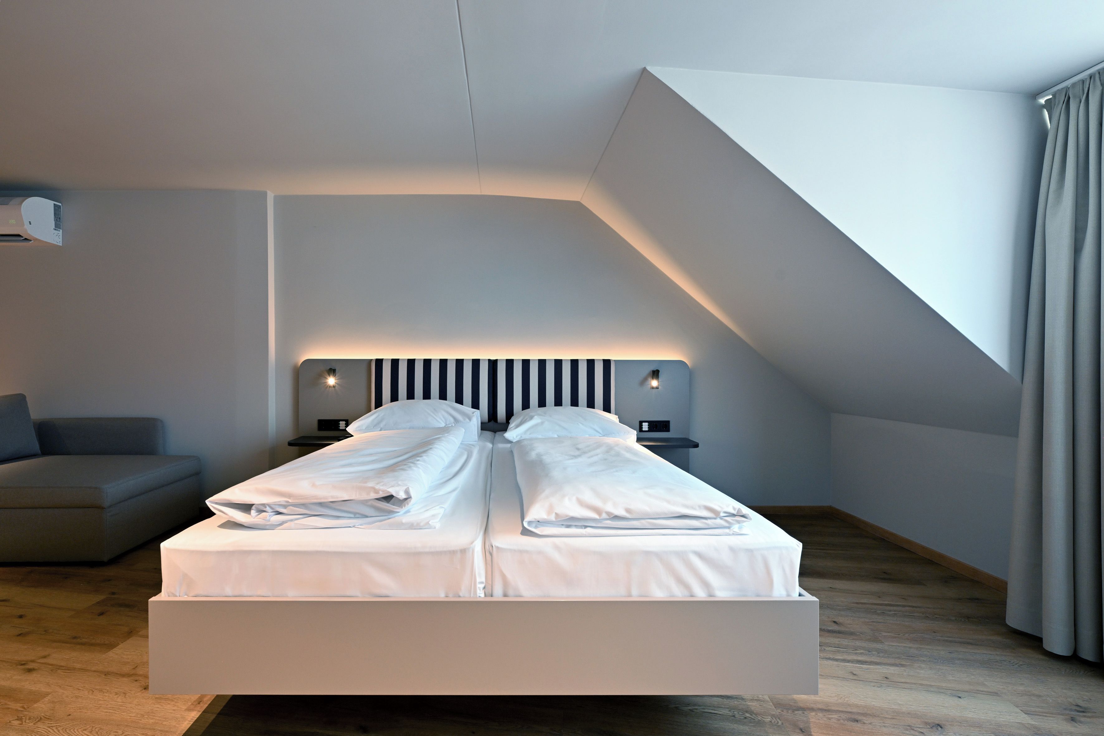 A modern bedroom with a bed, bedside tables, and a built-in bench.