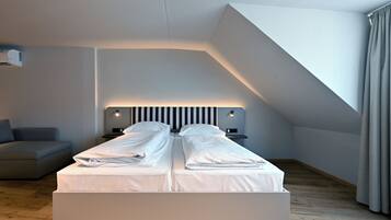 A modern bedroom with a bed, bedside tables, and a built-in bench.