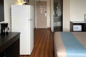A hotel room with a bed, a kitchenette, a refrigerator, and a coffee maker. - 1 King Bed | Non-Smoking, Kitchen (Las Cruces)
