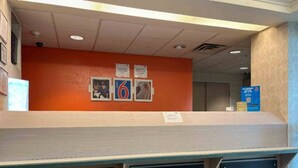 A reception area with a counter, a wall-mounted number sign, and a blue sign with QR code. - 1 King Bed | Non-Smoking, Kitchen (Las Cruces)