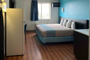 Une chambre avec un lit, un bureau et une fenêtre.