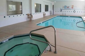 Ein Hallenbad mit Fliesenboden, einer Metallleiter und einem Stuhl.