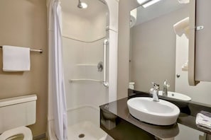Une salle de bain moderne avec une douche à l’italienne, un grand lavabo et un miroir.