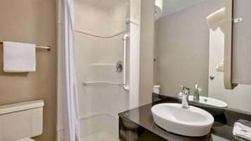 A modern bathroom with a walk-in shower, a large sink, and a mirror.