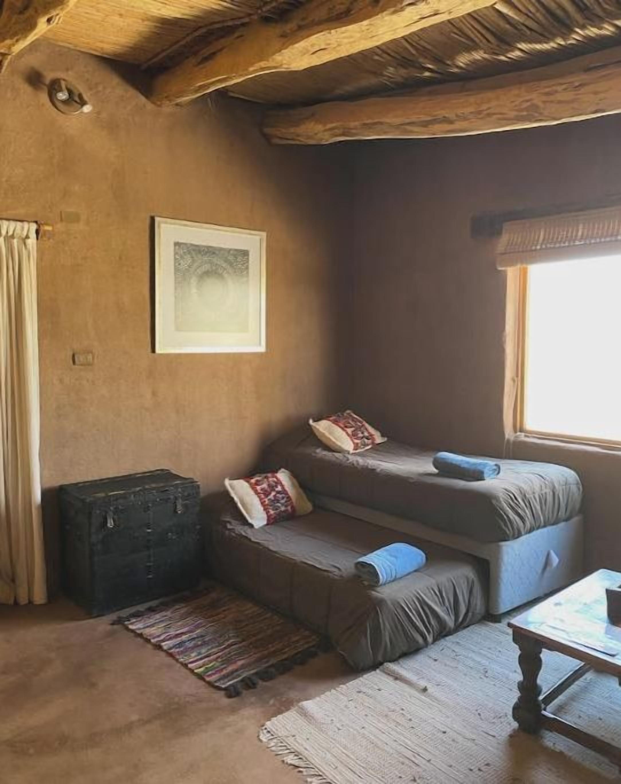 A cozy room with a sofa, a small table, a window, and a framed picture on the wall.