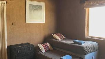 A cozy room with a sofa, a small table, a window, and a framed picture on the wall.