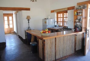 A kitchen with a central island, wooden cabinets, a refrigerator, and a sink.
