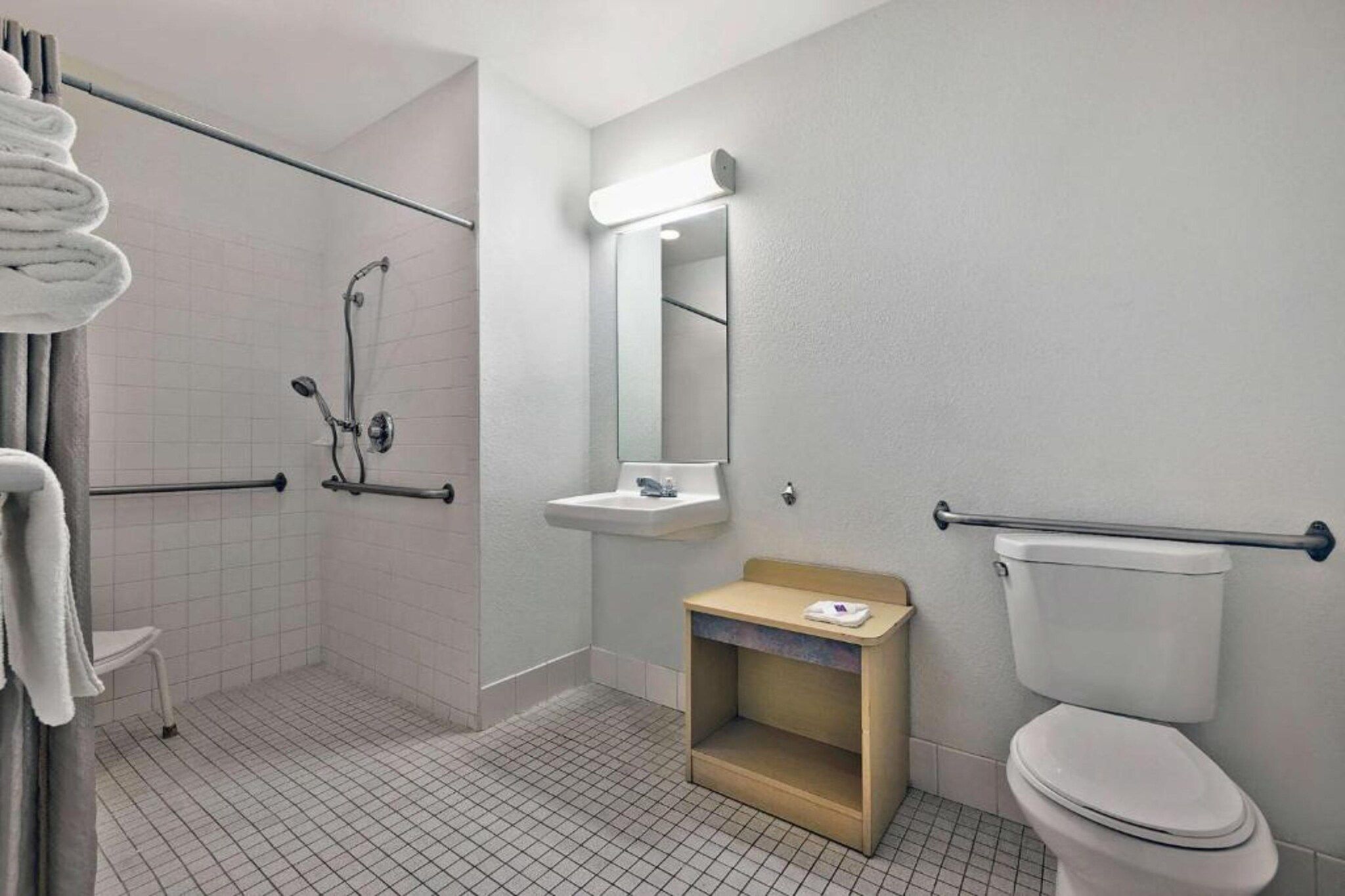 Un baño con ducha, inodoro, lavamanos y espejo.