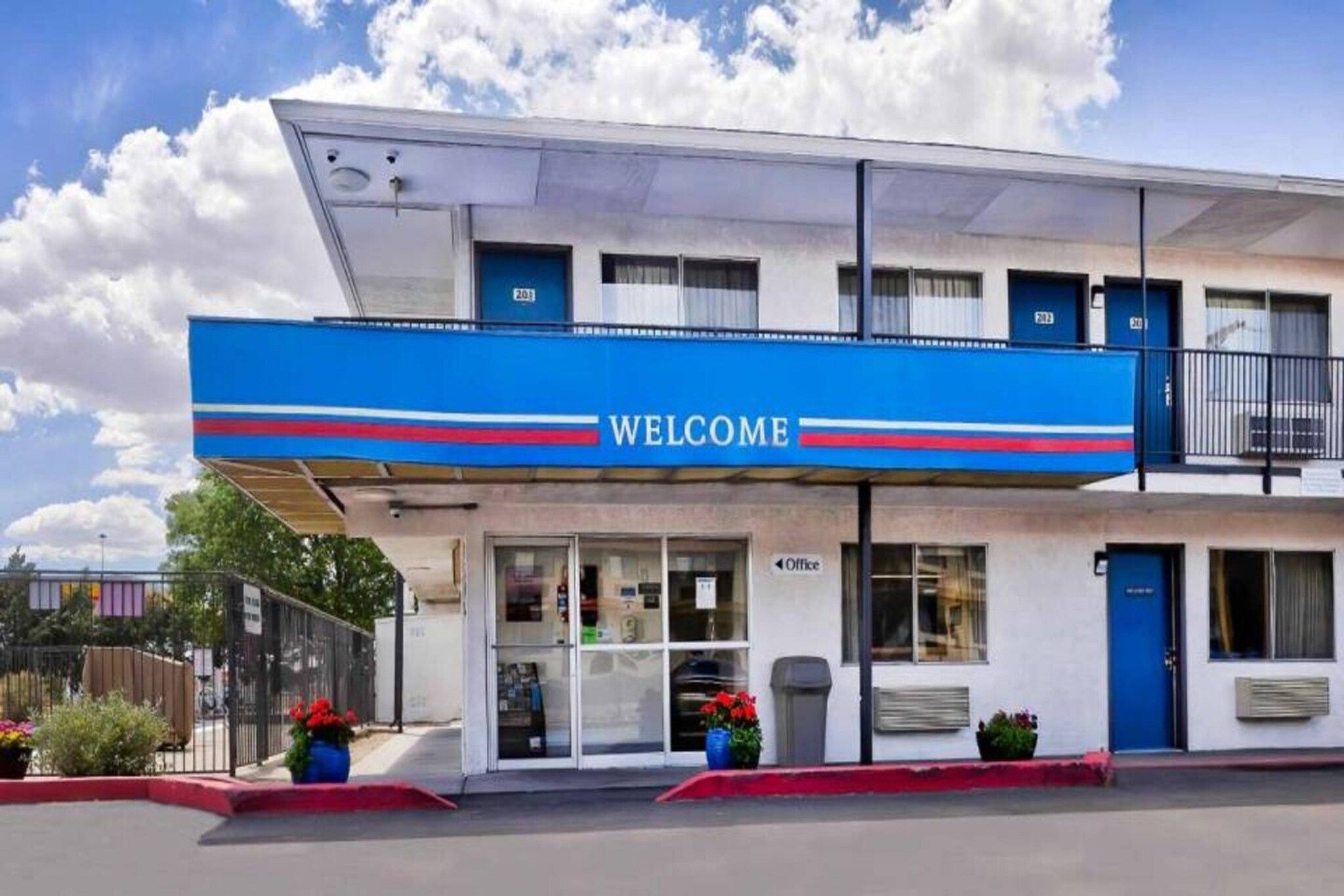 Een gebouw met twee verdiepingen en een blauw doek met de tekst 'WELCOME'.