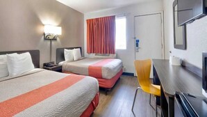A hotel room with two beds, a desk, a chair, a television, and a window with curtains. - Spacious 2 Full Beds |Motel 6 Gallup, NM (Gallup)