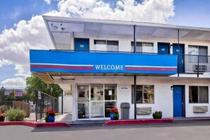 Een gebouw met twee verdiepingen en een blauw doek met de tekst 'WELCOME'.